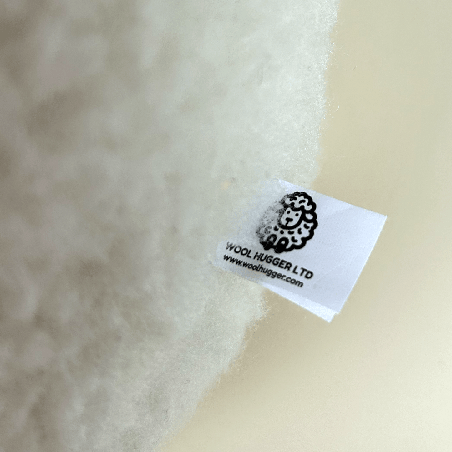Wool fabric with a label from Wool Hugger Ltd on a beige background