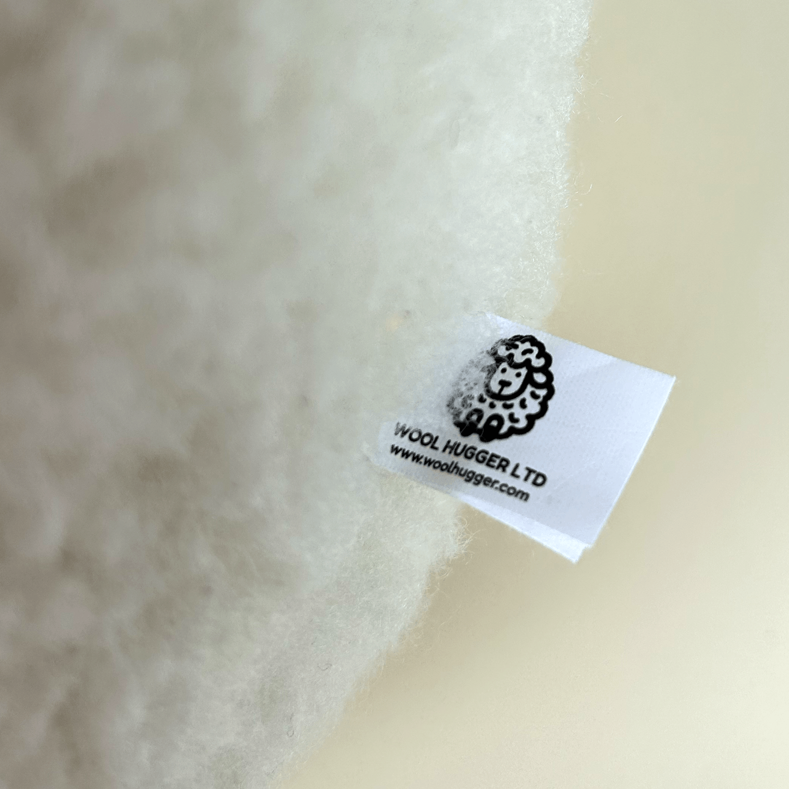 Wool fabric with a label from Wool Hugger Ltd on a beige background