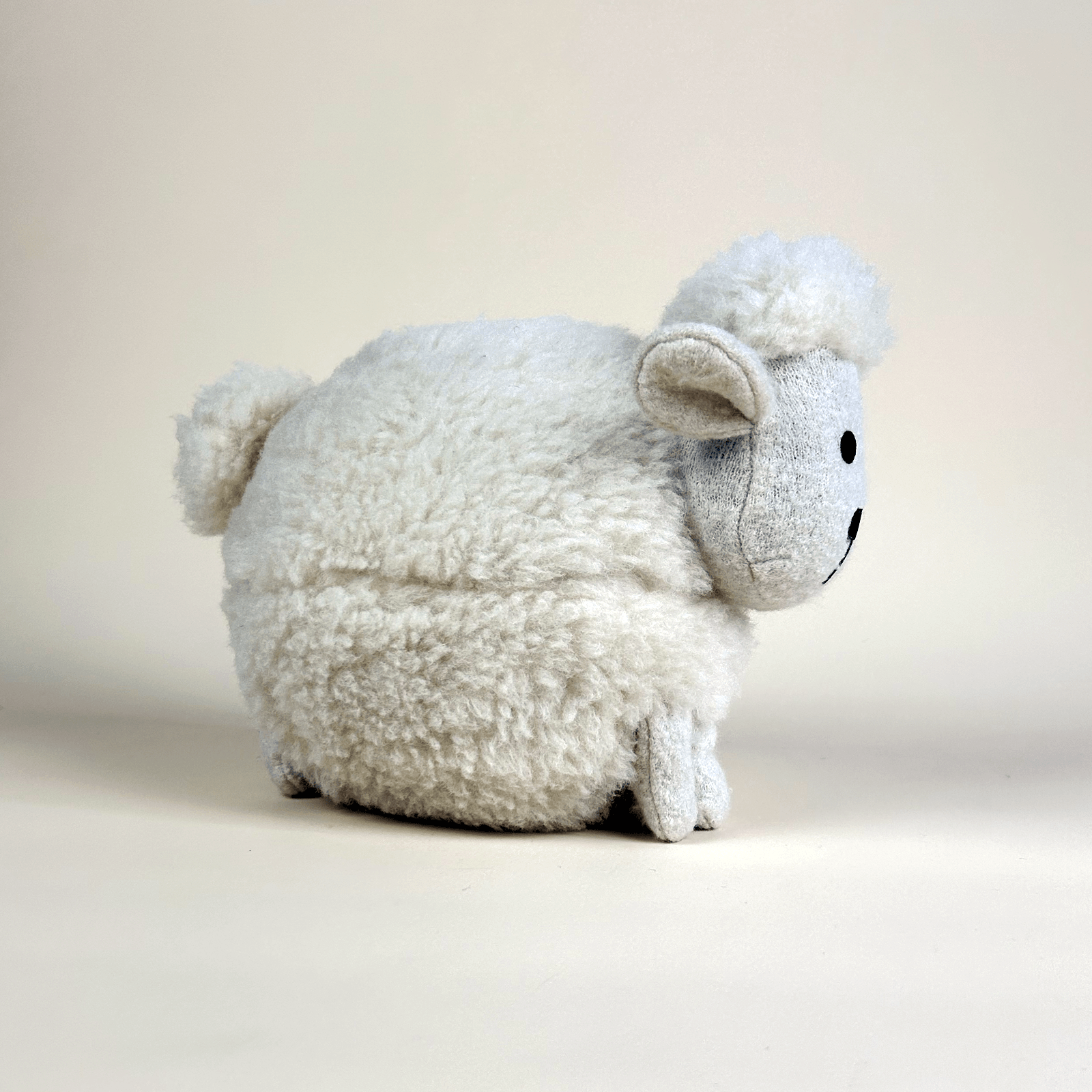 100% wool plush sheep toy on a plain background