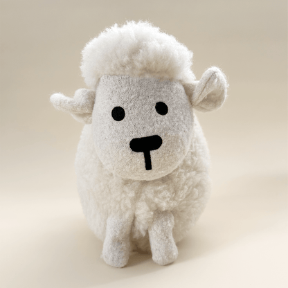 Wool plush toy sheep on a beige background