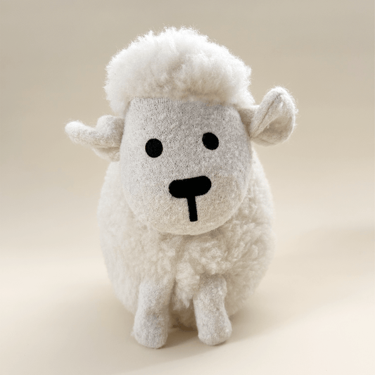 Wool plush toy sheep on a beige background
